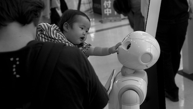 Baby berührt Gesicht von Roboter