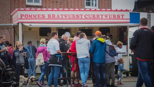 Deutsche vor einem Pommes-, Bratwurst-Stand