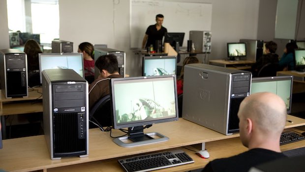 Mann sitzt am Computer im Großraumbüro